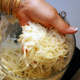 Grate potatoes on a box grater or in your food processor.